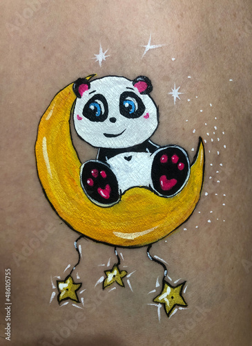 the panda character sits on a yellow moon with stars and smiles. cartoon  hand drawing  on  beige background
