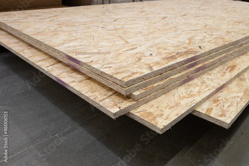 OSB pressed wood sheets stacked in store. Construction materials photo
