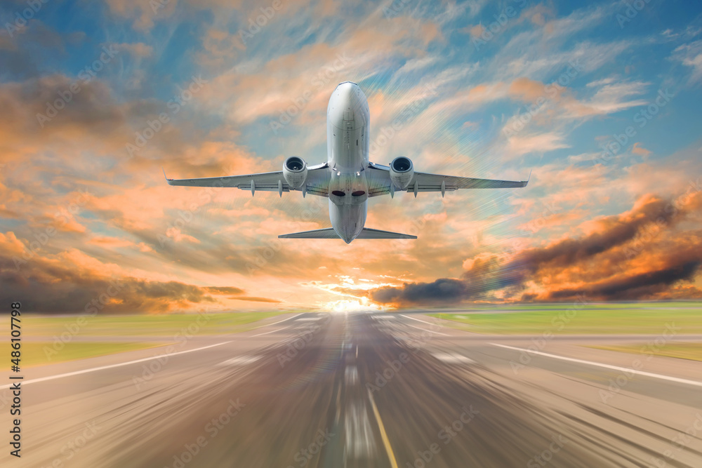 Taking off a passenger commercial jet liner against the backdrop of a beautiful sky in the evening sunset, and the effect of movement speed motion on the runway. Taking off a passenger commercial jet liner against the backdrop of a beautiful sky in the evening sunset, and the effect of movement speed motion on the runway.