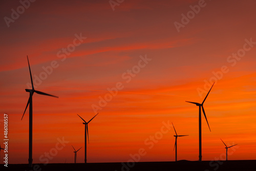 Sunset over an eolian wind farm with amazing sky color. Alternative eco energy good for the environment. Renewable energy industry. © Dragoș Asaftei