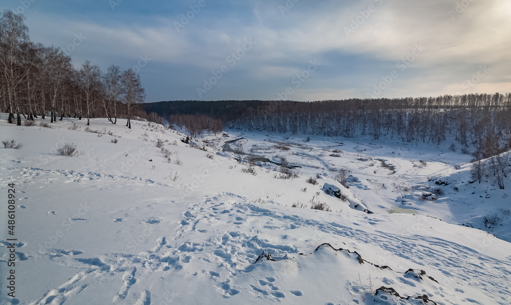 Winter landscape with trees and sky from the high rocky river bank Winter landscape with trees and sky from the high rocky river bank