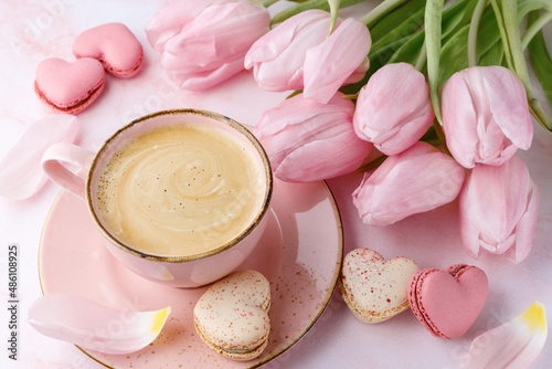 Vintage pink coffee cup, tulip flowers and french sweet cookies macarons macaroons  on marble background