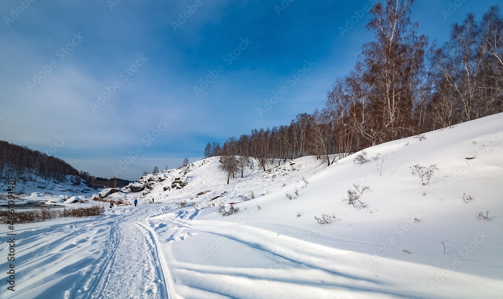 Winter landscape with trees and sky from the high rocky river bank