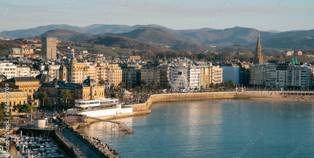 Naklejka premium View of San Sebastian Donostia at sunset. View of the Alderdi Eder, the City Hall Nautical Club and the Ferris wheel.