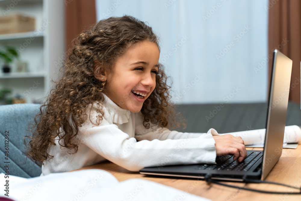 Multiracial girl laughing out loud while looking at the laptop screen Multiracial girl laughing out loud while looking at the laptop screen