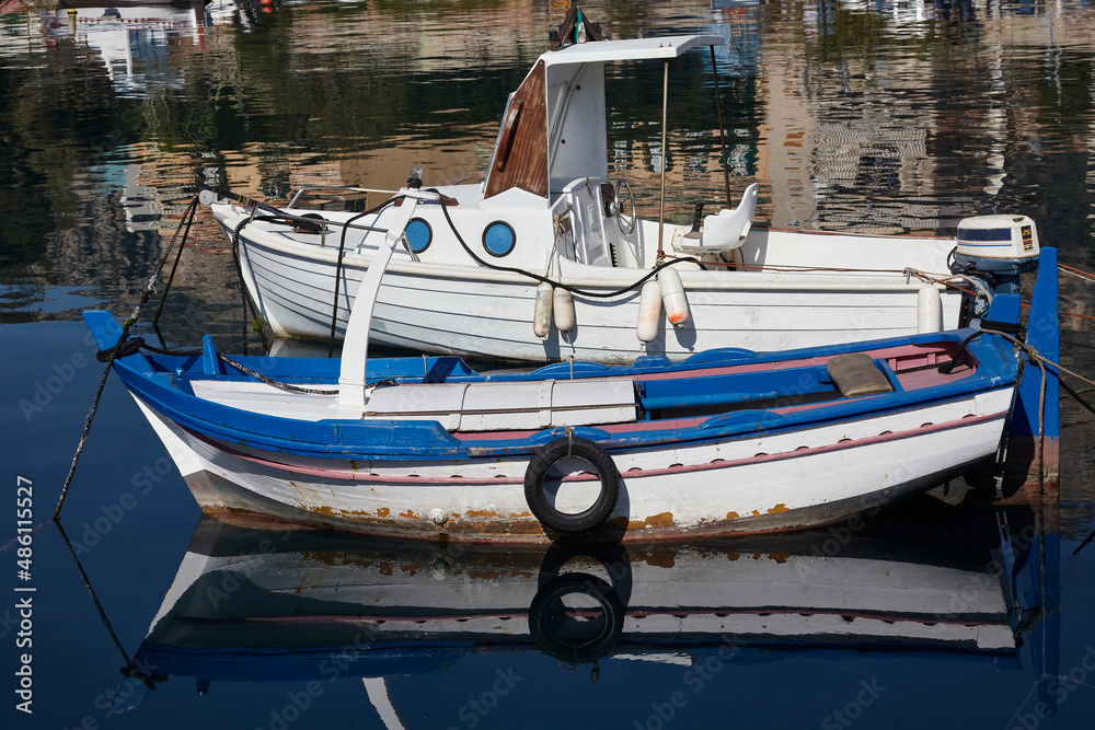 Fishing boats with motor and oars, moored in a small port of a fishing village
