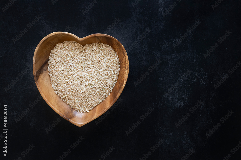 Obraz premium Heart-shaped bowl with brown rice