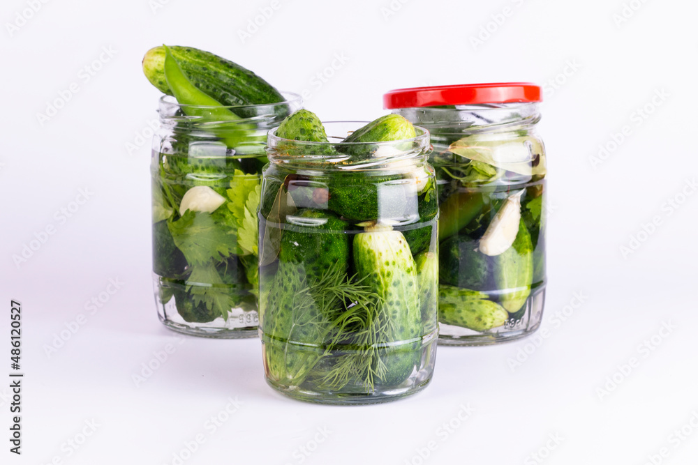 Pickled cucumbers in glass jar on white background. Pickled cucumbers in glass jar on white background.