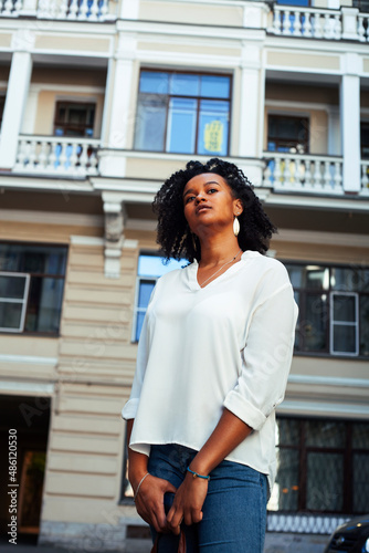 young pretty african girl posing cheerful on city background, lifestyle outdoor people concept