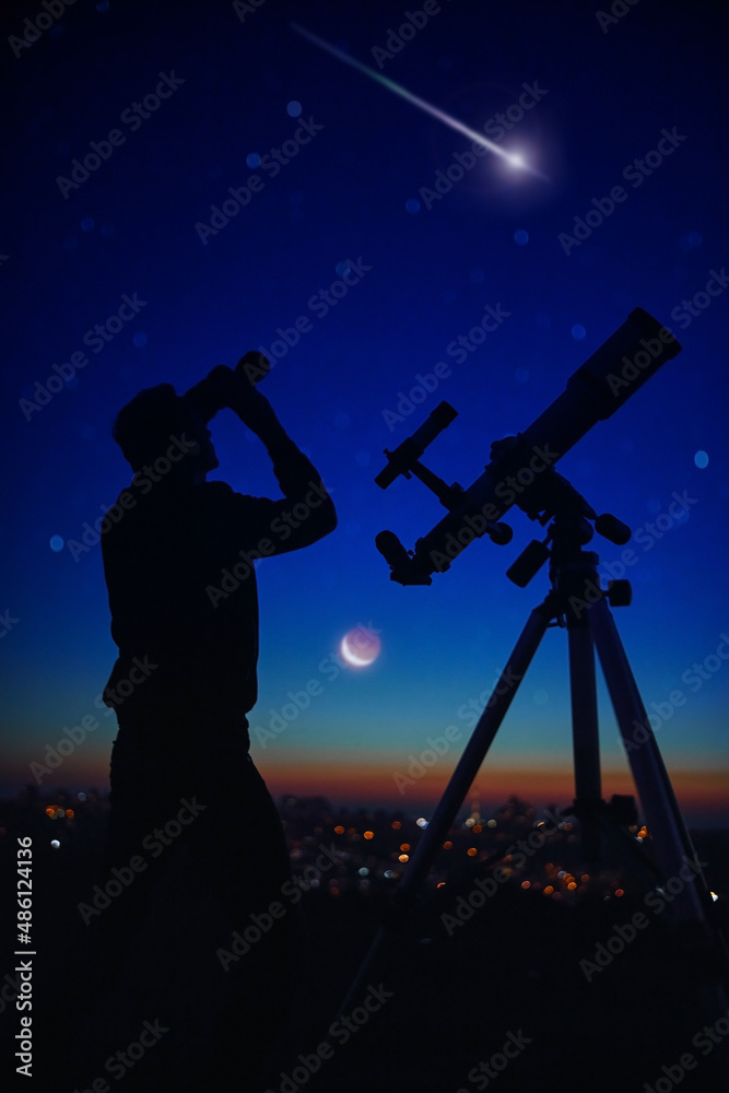 Silhouette of a man while watching starry skies with astronomy telescope and binoculars.