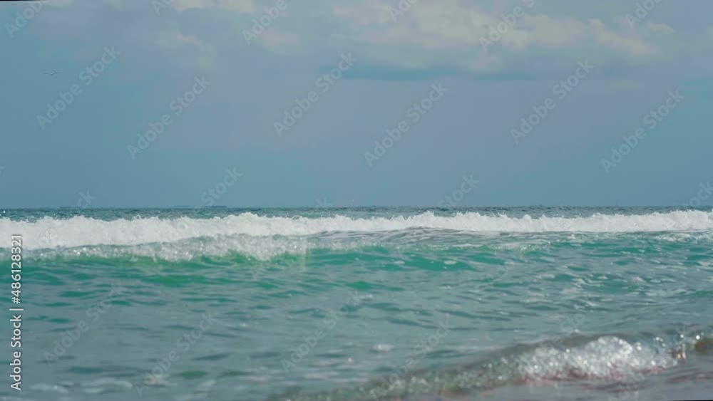 Windy day, agitated, white foamy sea waves. Many big ships floating on the sea, far on the horizon. Windy day, agitated, white foamy sea waves. Many big ships floating on the sea, far on the horizon.