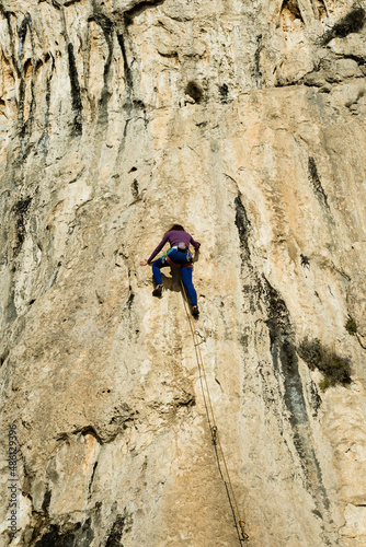 Beautiful Woman Climbing on the High Rock . Adventure and Extreme Sport Concept