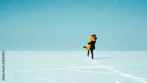 Happy walking couple. In love man and woman walking on the snowy ice. Winter vacation concept. Happy Valentines day concept.