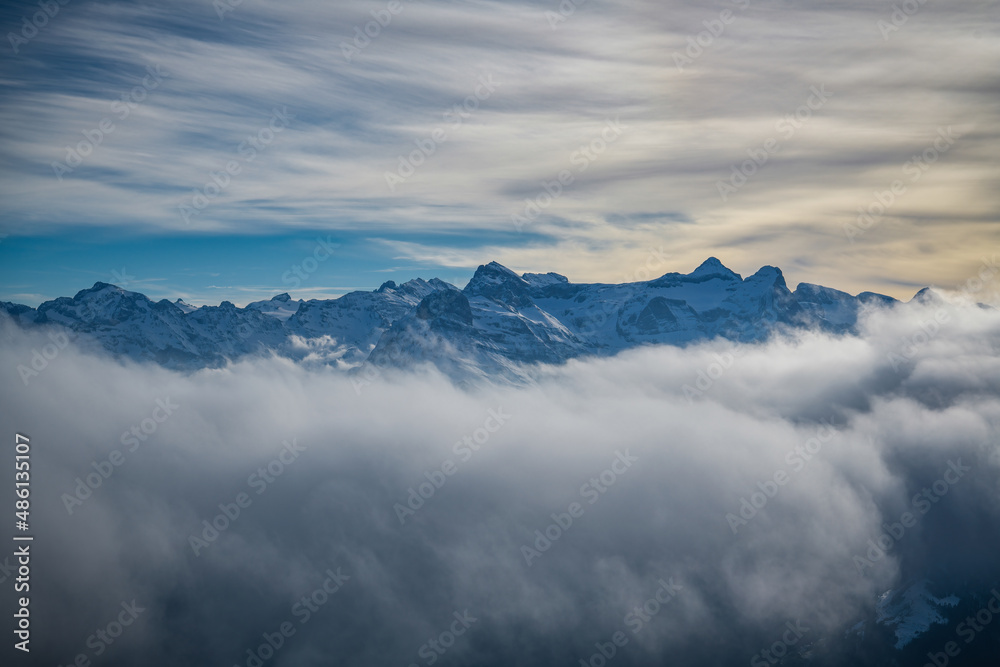 Snowy mountains hiding behind the clouds as seen from Fronalpstock peak Snowy mountains hiding behind the clouds as seen from Fronalpstock peak
