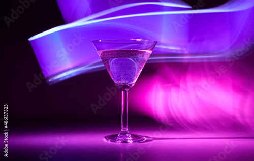 Martini cocktail drink in neon iridescent pink and blue colors.