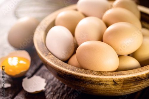 free-range chicken eggs in hand-made rustic wooden bowl, organic rustic cuisine