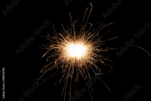 Burning sparkler isolated on black background. Fireworks theme. Light effect and texture.