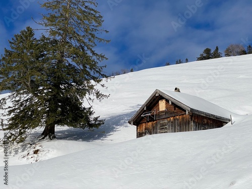 Idyllic Swiss alpine mountain huts dressed in winter clothes and in a fresh snow cover on slopes on the Alpstein mountain range - Mountain pass Schwägalp, Switzerland (Schweiz) © Mario