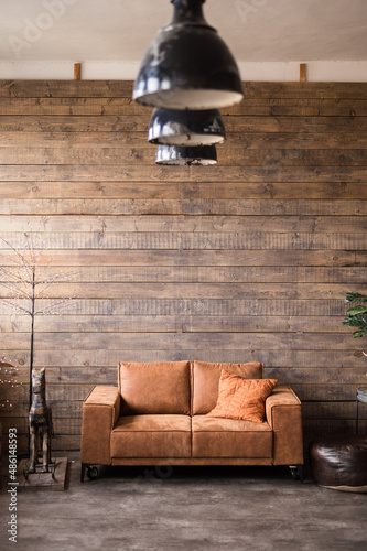 living room interior with leather sofa brown wood plank wall old lamps