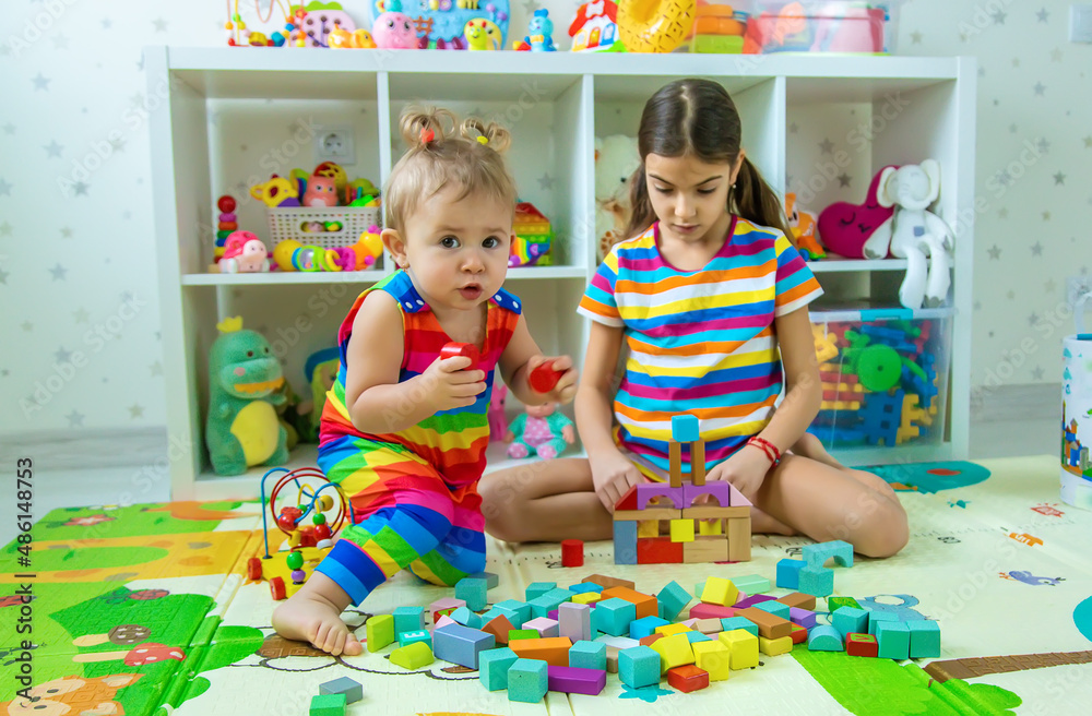 Fototapeta premium Children play together in the playroom. Selective focus.