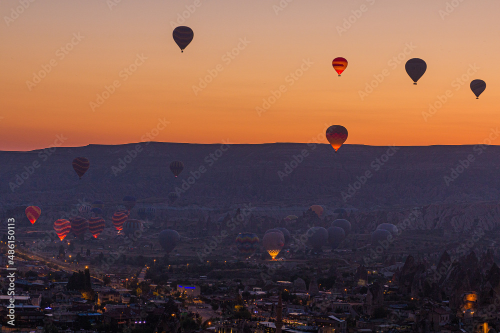 Early morning view of hot air balloons above Goreme village in Cappadocia, Turkey