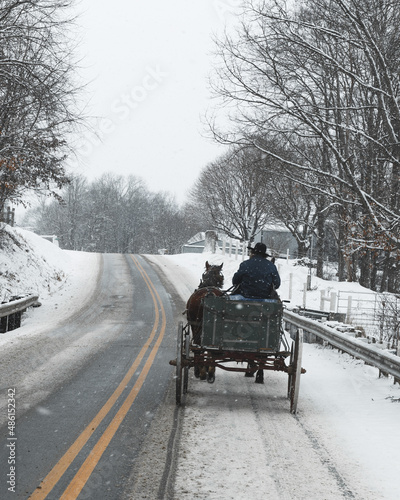 Amish Man Driving a Horse and Buggy Going Away From Camera on a Snowy Road in Ohio's Amish Country