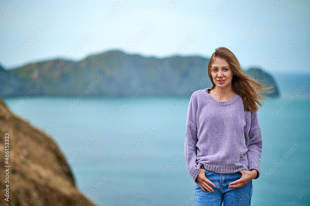 girl against background of sea and rock girl against background of sea and rock
