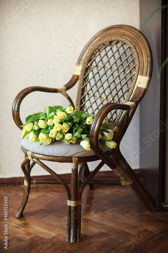 Vintage stylish rattan chair with yellow tulips