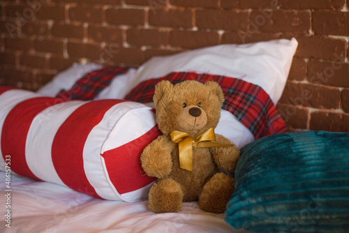 Cute romantic teddy bear on the cozy sofa in the loft with brick wall
