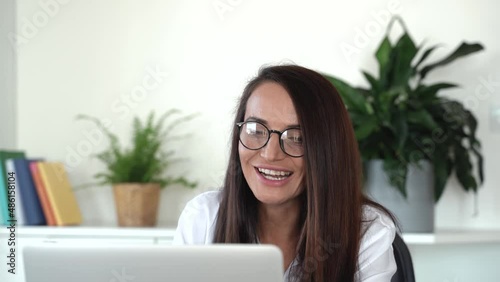 Smiling young female psychotherapist using online healthcare app on laptop, planning patients appointment in clinic office. Smilling doctor talk and consult patient by video call. 4k footage