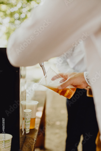 Invité remplissant son verre à l'aide d'une tireuse à bière photo