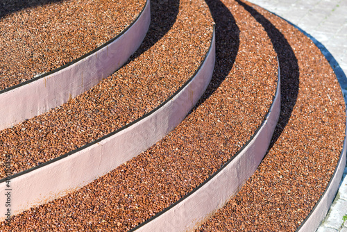 Coating of the stairs with small red pebble stones for creative design. Selective focus.