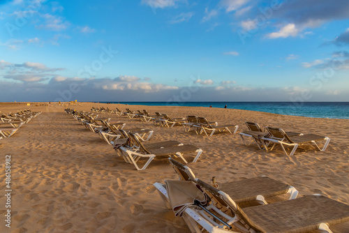Sun loungers on a deserted sandy beach  © Nataliya Schmidt