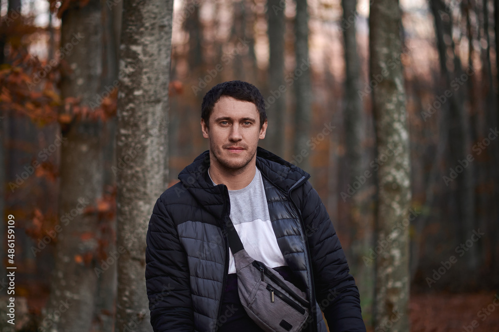 a man in a yellow autumn bright forest with a bag across his chest a man in a yellow autumn bright forest with a bag across his chest