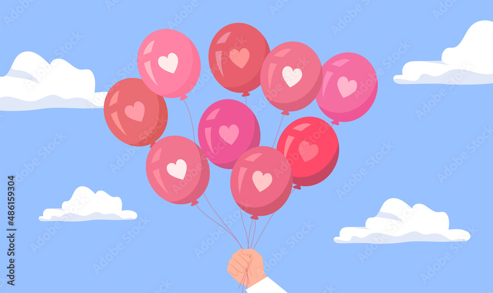 A hand holds many pink balloons with hearts on sky background. Romantic Valentine's greeting card 