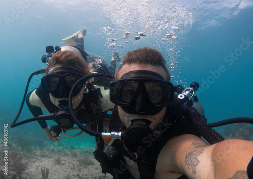 young couple scuba diving and taking a selfie