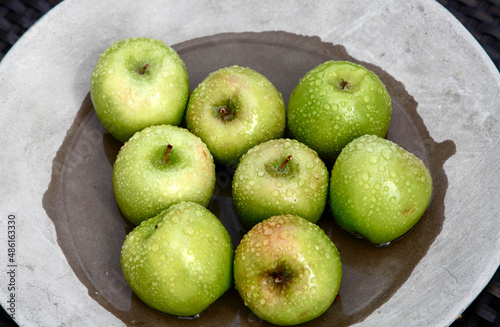 Granny Smith Apples on Stone Plate after Rain, San Rafael, CA, US photo