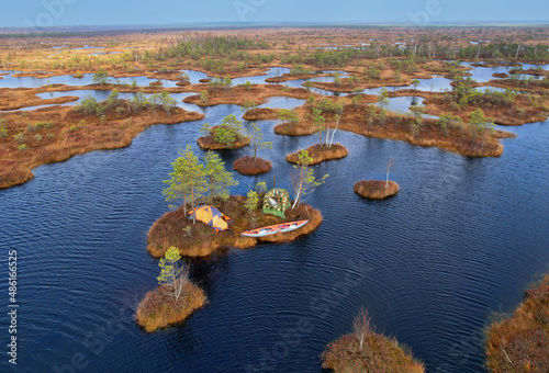 Boating on bog. Trip on Swamp Yelnya in autumn. Adventure on kayak in Wild mire. Camping in a tent in wild nature on marshland. Ecological reserve in wildlife. Swampy land and wetland, marsh. . photo