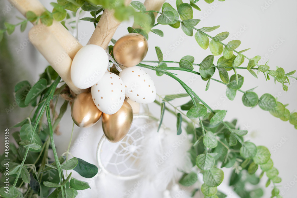 Dyed golden eggs on top of a boho teepee with dream catcher and eucalyptus. Decorations for Easter. Dyed golden eggs on top of a boho teepee with dream catcher and eucalyptus. Decorations for Easter.