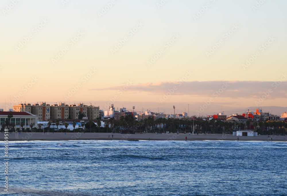 View on coastline and beach from La Marina de Valencia on the sea to the Las Arenas beach, Playa de las Arenas, Platja del Cabanyal and Playa de la Malvarrosa. Waves at sea on sunset.