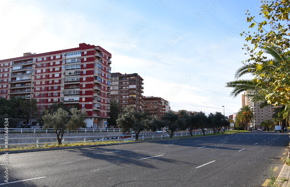 Valencia city street, road traffic, cars on road, people and buildings. Urban architecture, square, trees in parks and panarama. Car in motion on city streets. December 15, 2021, Spain, Valencia.