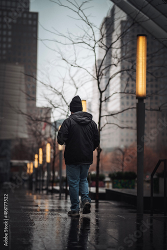 Man walking in the rain by the oculus building 