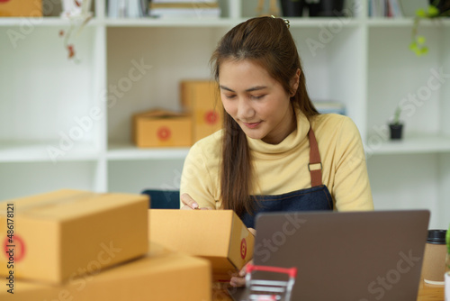 Female entrepreneur prepare packing a delivery package of her customers. © bongkarn