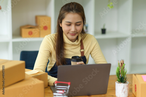 Female online shopping business owner working on laptop