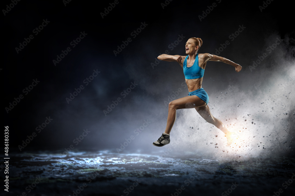 Young beautiful girl doing exercise against dark background