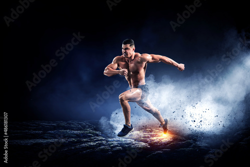 Male runner against dark background © Sergey Nivens