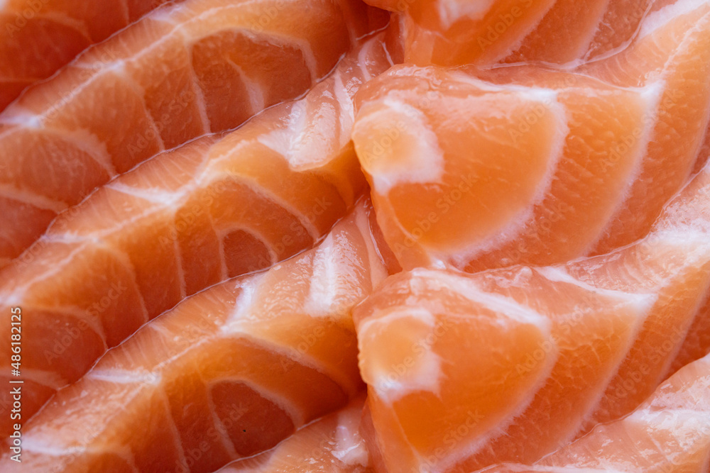 close up salmon fillet slices texture.Row salmon fish sliced on plate at Japanese restaurant.