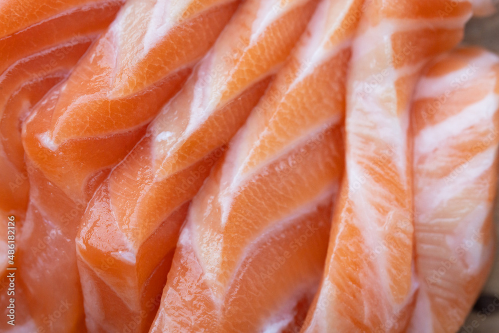 close up salmon fillet slices texture.Row salmon fish sliced on plate at Japanese restaurant. close up salmon fillet slices texture.Row salmon fish sliced on plate at Japanese restaurant.
