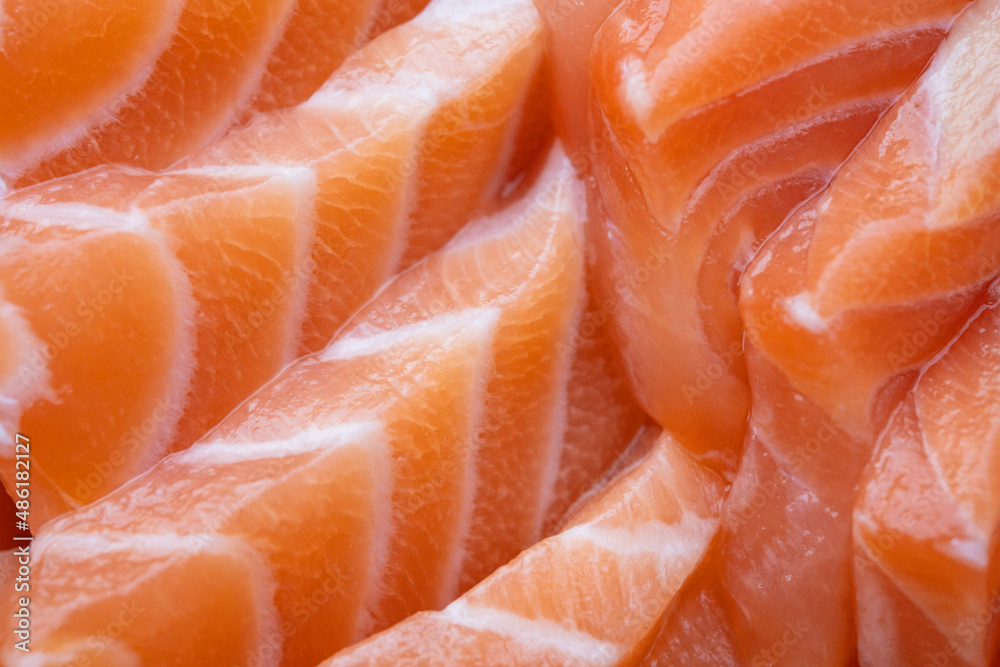 close up salmon fillet slices texture.Row salmon fish sliced on plate at Japanese restaurant. close up salmon fillet slices texture.Row salmon fish sliced on plate at Japanese restaurant.