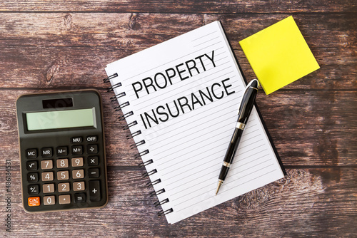 Property Insurance Text on Note Pad With Calculator-Business concept